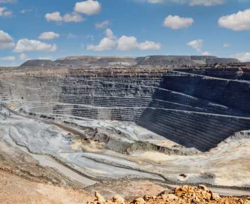 Panoramic view of an open pit mine with machinery in the background.